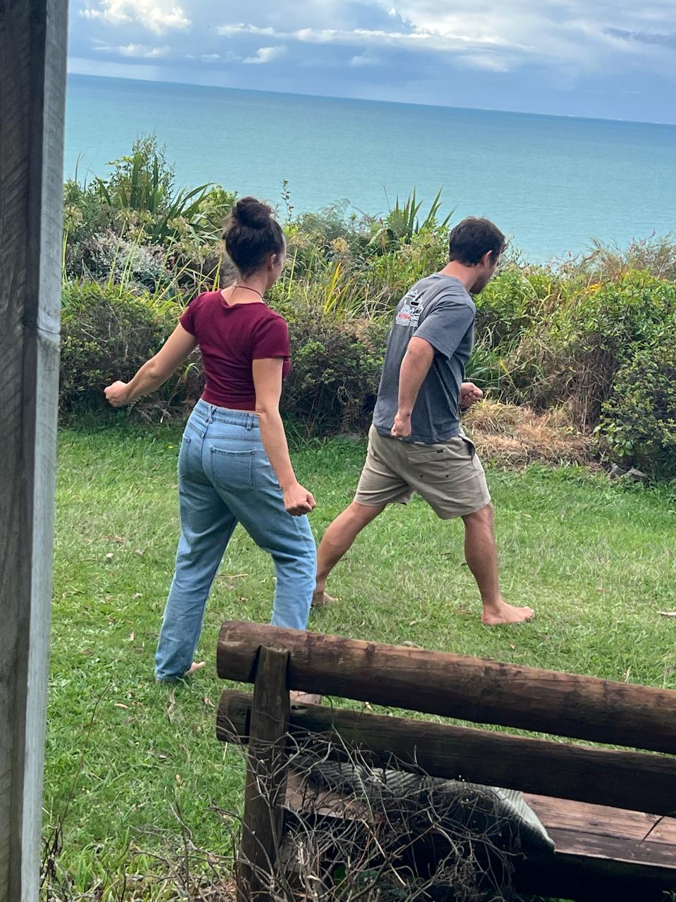 A couple walking on the grass by the ocean