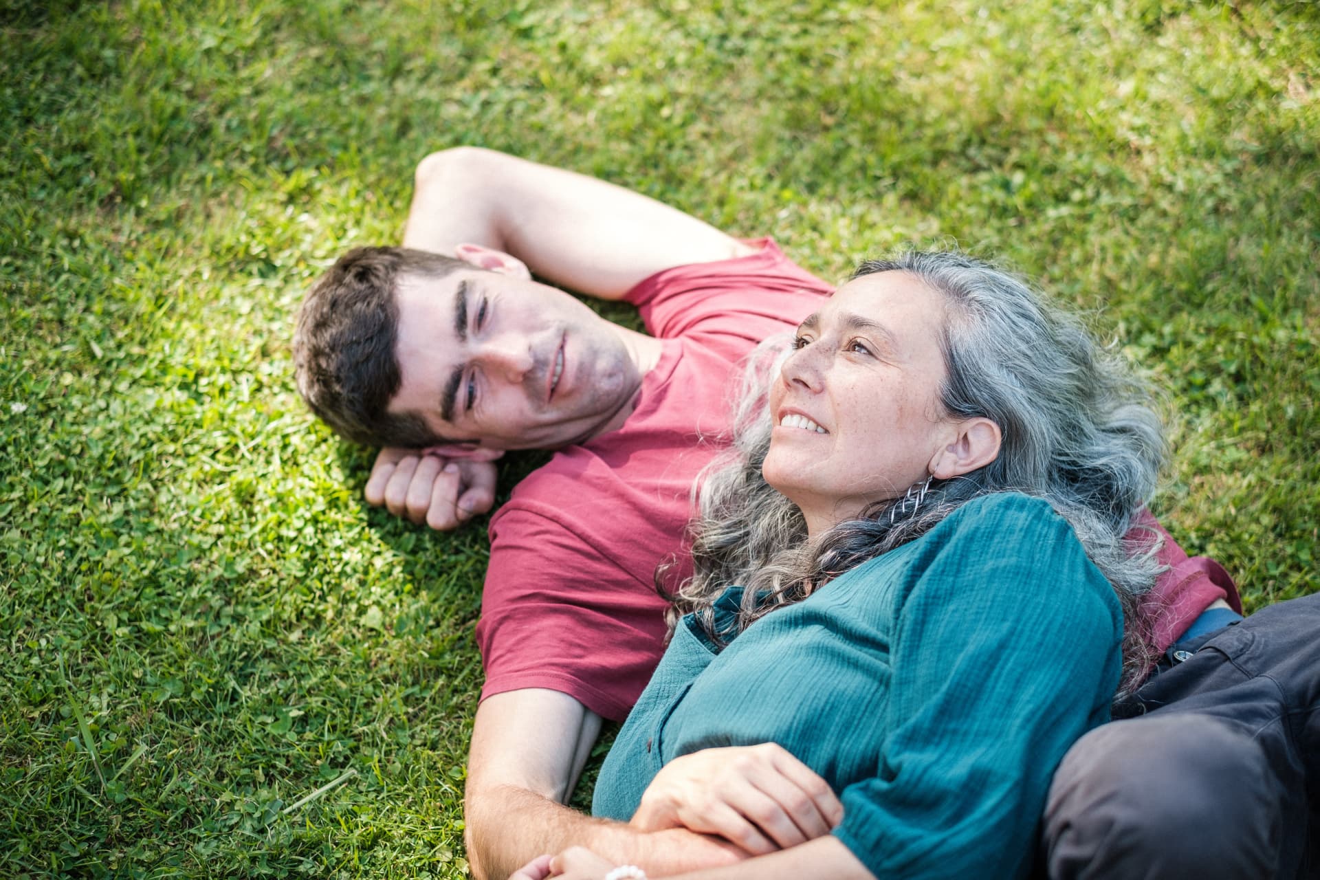 A couple lying together in the grass, laughing