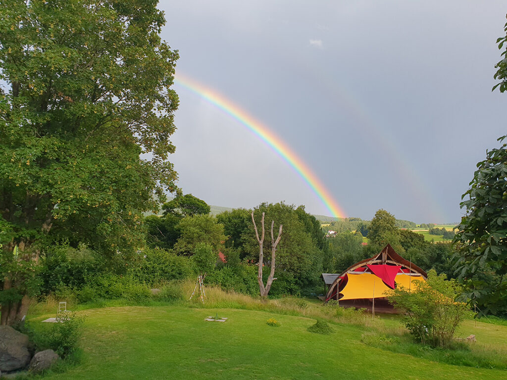 A rainbow over the meadow and seminar tent at Nature Community