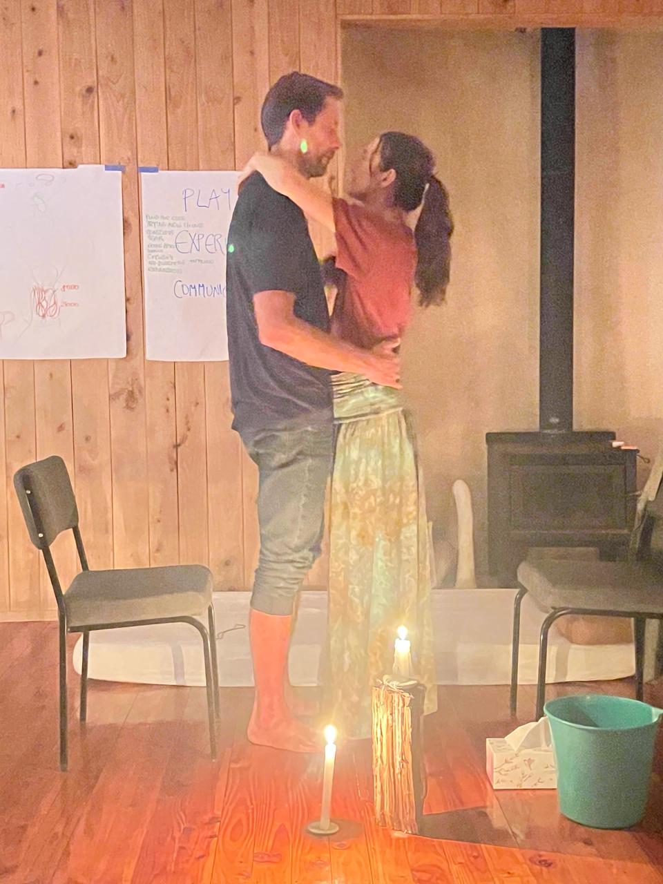 A couple embracing in the seminar room by candlelight