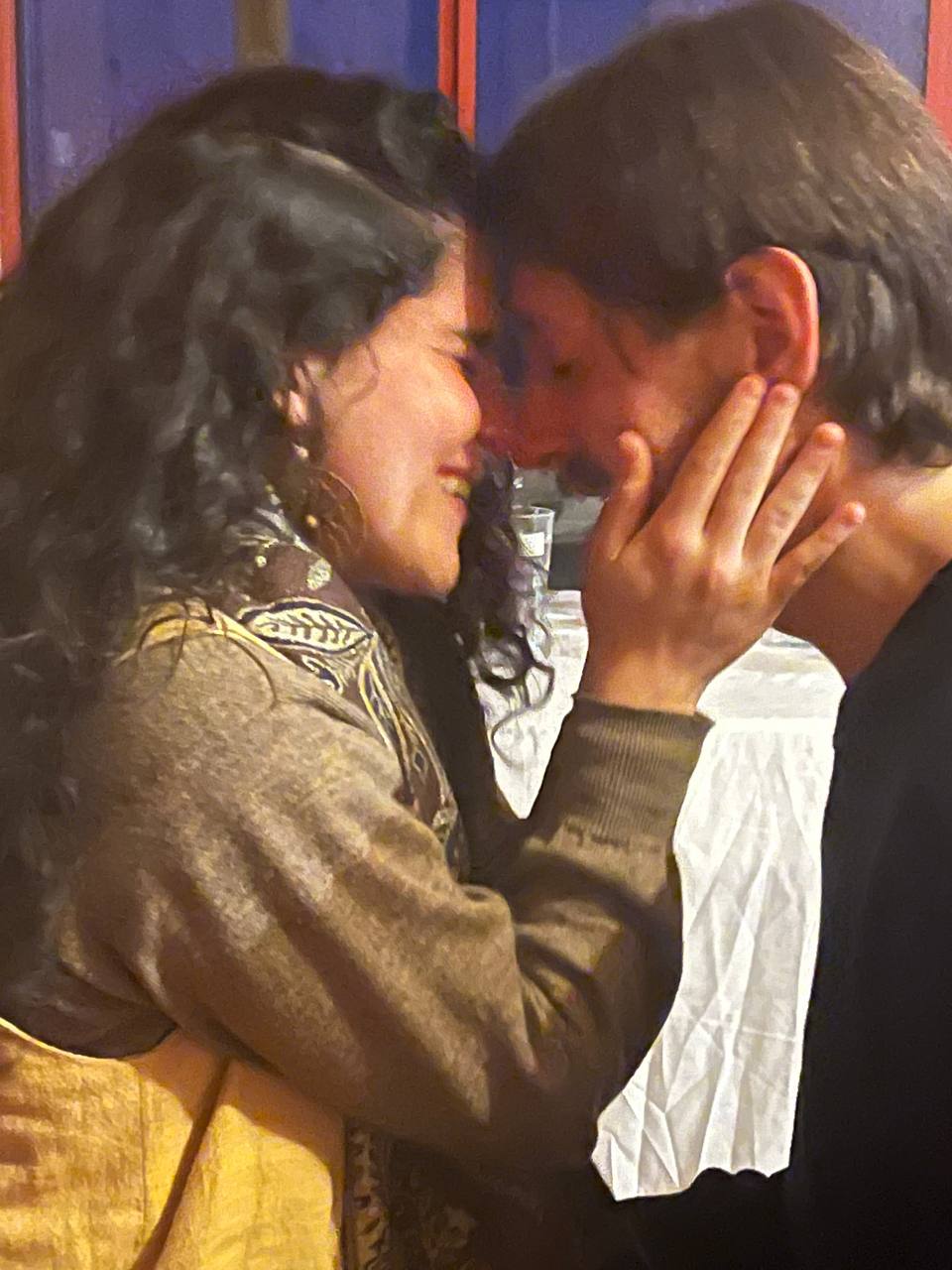 A couple resting forehead to forehead in warm candlelight